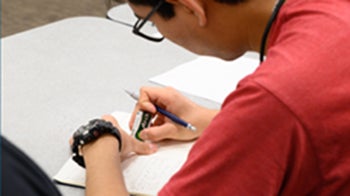 A male student works on an assignment. 