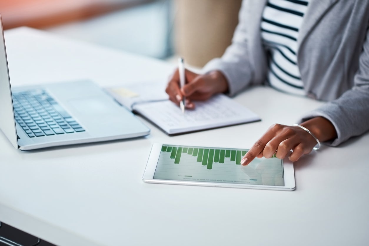 person analyzing data graphs on an iPad