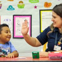 Literacy First tutor and student high-fiving