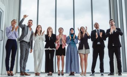 group of people dressed in business clothing applauding