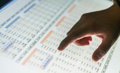 person pointing at numbers on a screen