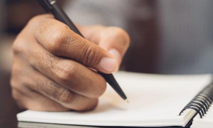 close up picture of hand writing in notebook