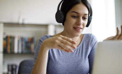 A young woman attends a webinar.