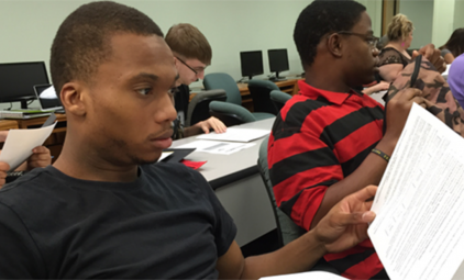 Several college-aged students work together in a mathematics classroom.