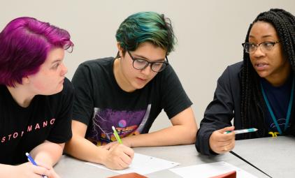 Three female students from Uri Treisman's freshman calculus class sit at a table discussing their work.