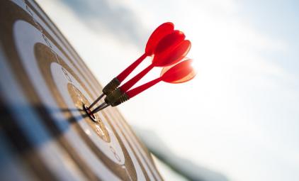 close up shot of darts in the bullseye of a dartboard