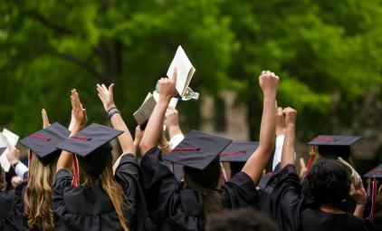 students celebrating in graduation caps and gowns
