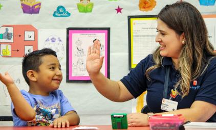 Literacy First tutor and student high-fiving