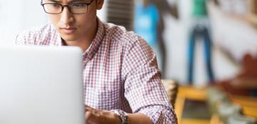 Young man on a laptop in a cafe.