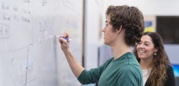 student writing on a whiteboard