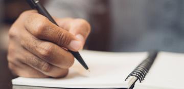 close up picture of hand writing in notebook