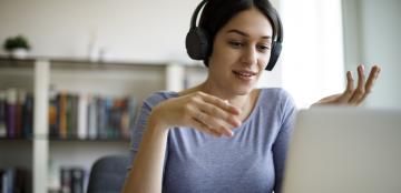 A young woman attends a webinar. 