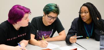 Three female students from Uri Treisman's freshman calculus class sit at a table discussing their work. 