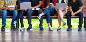 group of students sitting at a bench