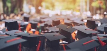 students in graduation caps and gowns outside