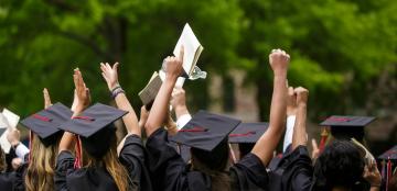 students celebrating in graduation caps and gowns