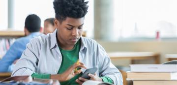 high school student at desk using a calculator