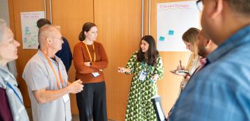 Group of educators standing in a circle discussing together