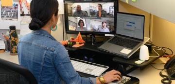 woman at a computer with a zoom meeting on her screen