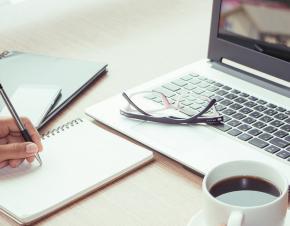 person working with laptop and notebook