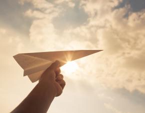 Paper airplane held in a child's hand.