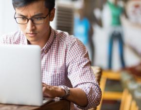 Young man on a laptop in a cafe.