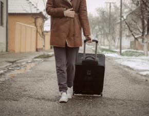 young woman walking with suitcase