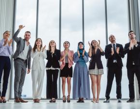group of people dressed in business clothing applauding