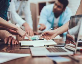 many hands working together over a table