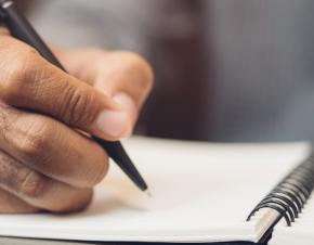 close up picture of hand writing in notebook