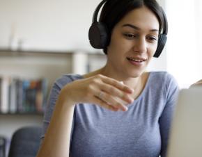 A young woman attends a webinar. 