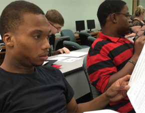 Several college-aged students work together in a mathematics classroom. 
