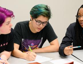 Three female students from Uri Treisman's freshman calculus class sit at a table discussing their work. 