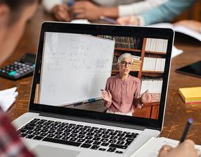 A student watches on his computer as an instructor presents a virtual lesson.