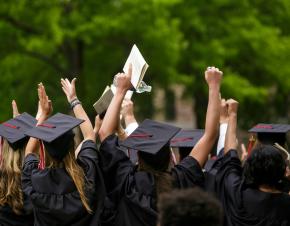 students celebrating in graduation caps and gowns