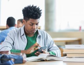 high school student at desk using a calculator