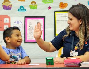 Literacy First tutor and student high-fiving
