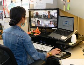 woman at a computer with a zoom meeting on her screen